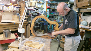Musician and luthier Mark Wahl bending wood for a guitar he’s building.