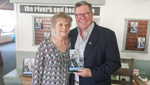 Former City of Oswego Mayor John T. Sullivan, right, is congratulated by Jeanne Byrne, secretary to City of Oswego Mayor William “Billy Barlow,” at a recent booksigning at the river’s end bookstore in Oswego.